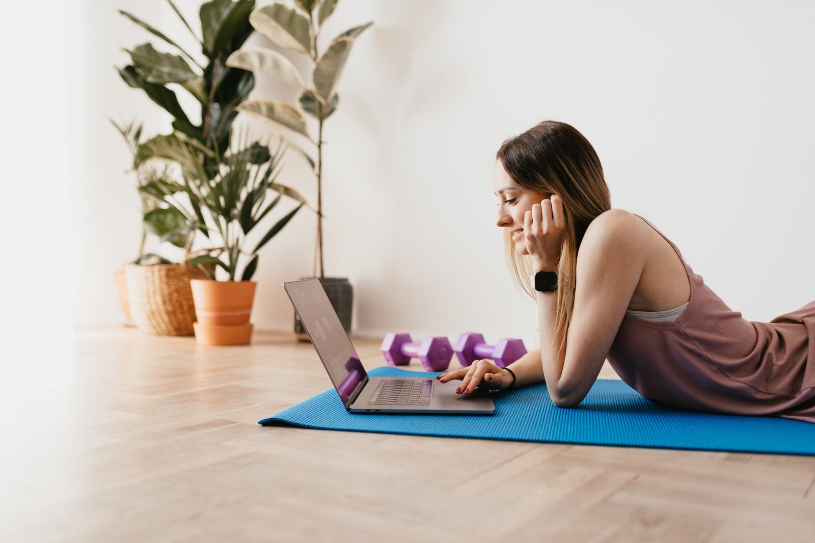 young sportive woman using laptop on floor