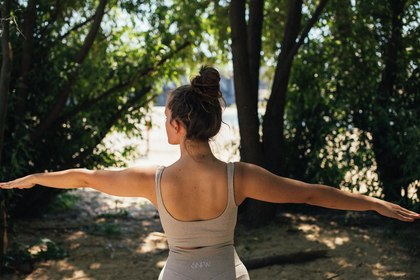 a woman in activewear doing yoga in the forest